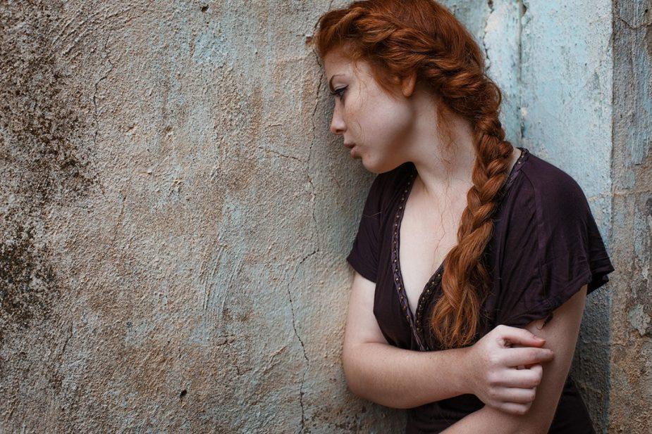 depresivna devojka naslonjena na zid - depresija