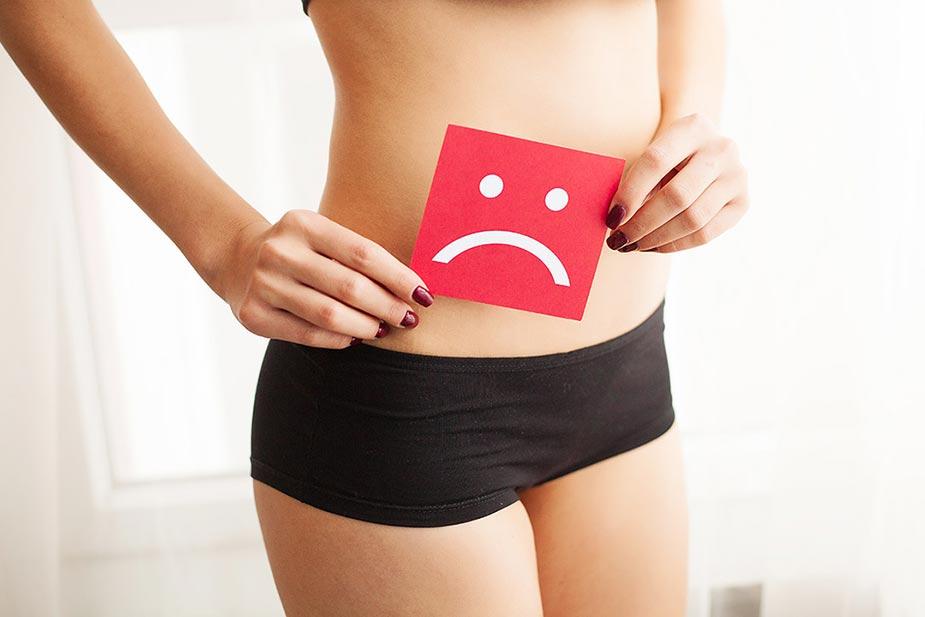 devojka u donjem vešu drži znak tužnog smajlija jer ima problem sa vaginalnom kandidom
