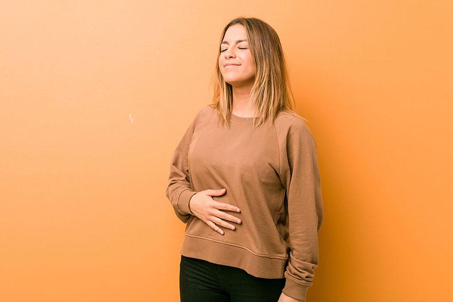 devojka se drži za stomak jer pati od nadutosti