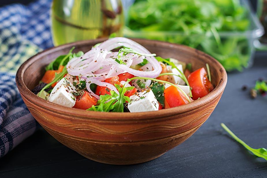 mediteranska dijeta je bogata salatama a na slici je keramička činija sa različitim svežim povrćem i feta sirom