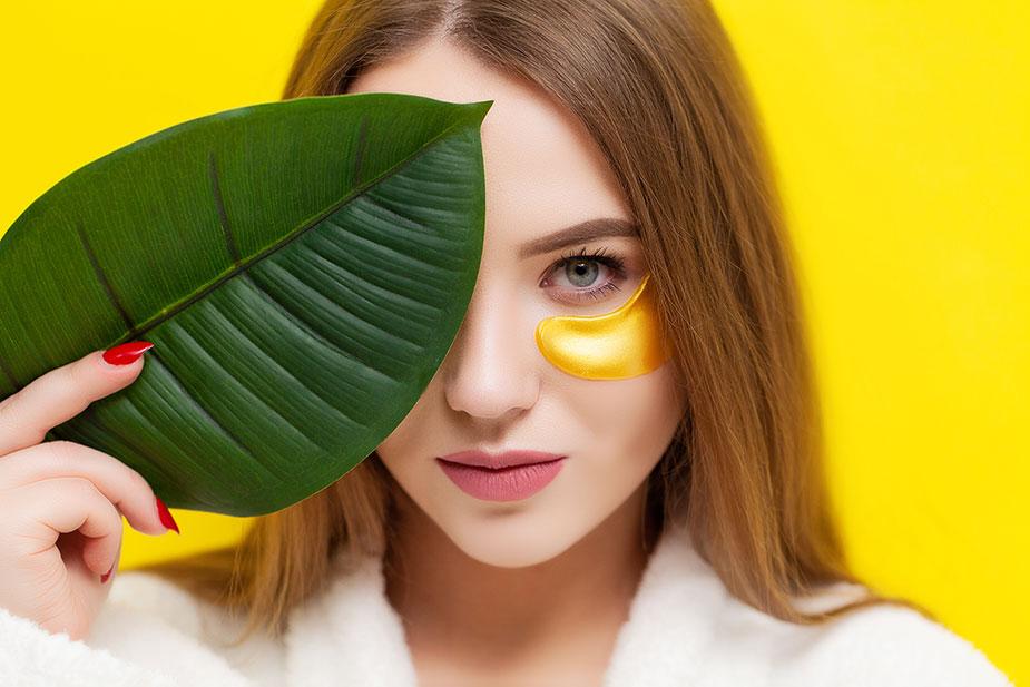 lice devojke koja velikim listom skriva oko a na drugom ima masku kojom se ublažavaju podočnjaci