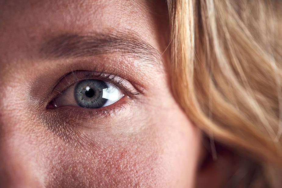 plavo žensko oko i plava kosa. u oku se vidi zabrinutost i stres