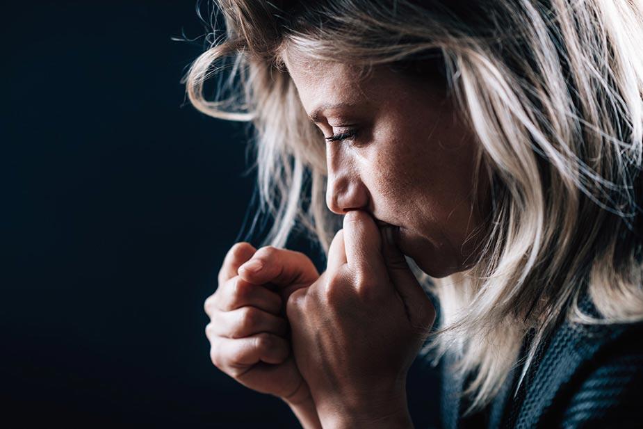 Profil glave žene sa dugom kosom i stisnutim i podignutim pesnicama kao da se brani od stresa