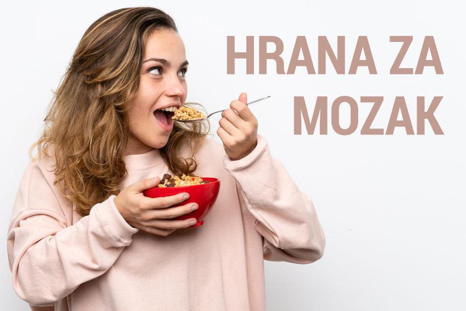 devojka sa širokim osmehom jede iz činije ovsenu kašu znajući da je to dobra hrana za mozak