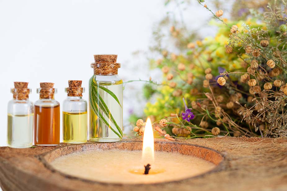 Eterična ulja u staklenim bočicam - ispred je sveća koja gori