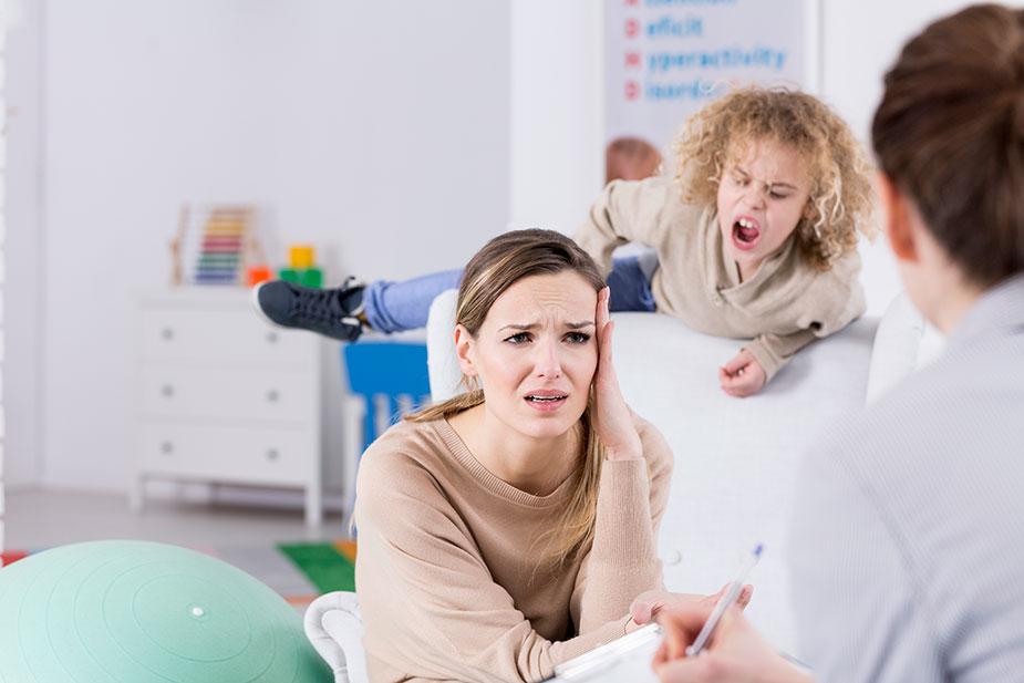 Majka razgovara sa stručnjakom dok joj hiperaktivno dete divlja iza leđa - Poremećaj pažnje