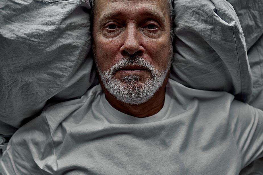 Stariji čovek leži u krevetu otvorenih očiju jer ga muči nesanica