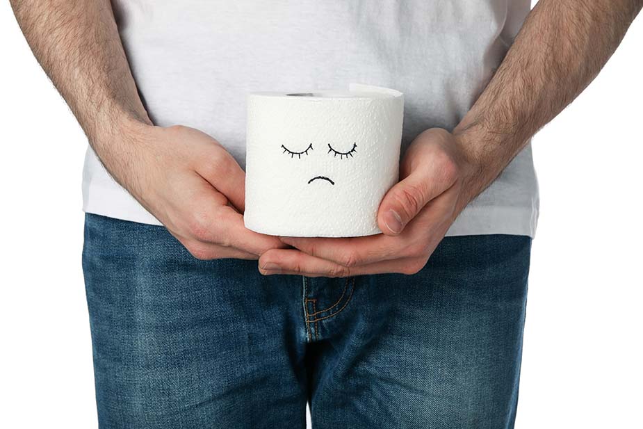 Muškarac drži rolnu toalet papira na kojoj je nacrtan tužni smajli