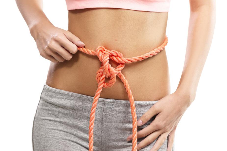 Mlađa žena sa kanapom oko struka vezanim u čvor - Opstipacija i konstipacija