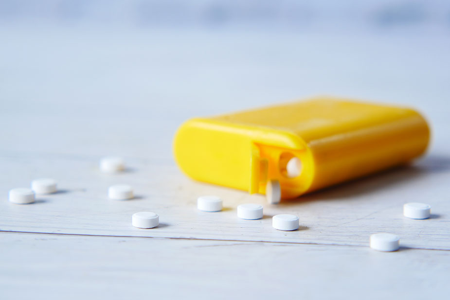 Žuta kutija na stolu sa tableticama veštačkog zaslađivača