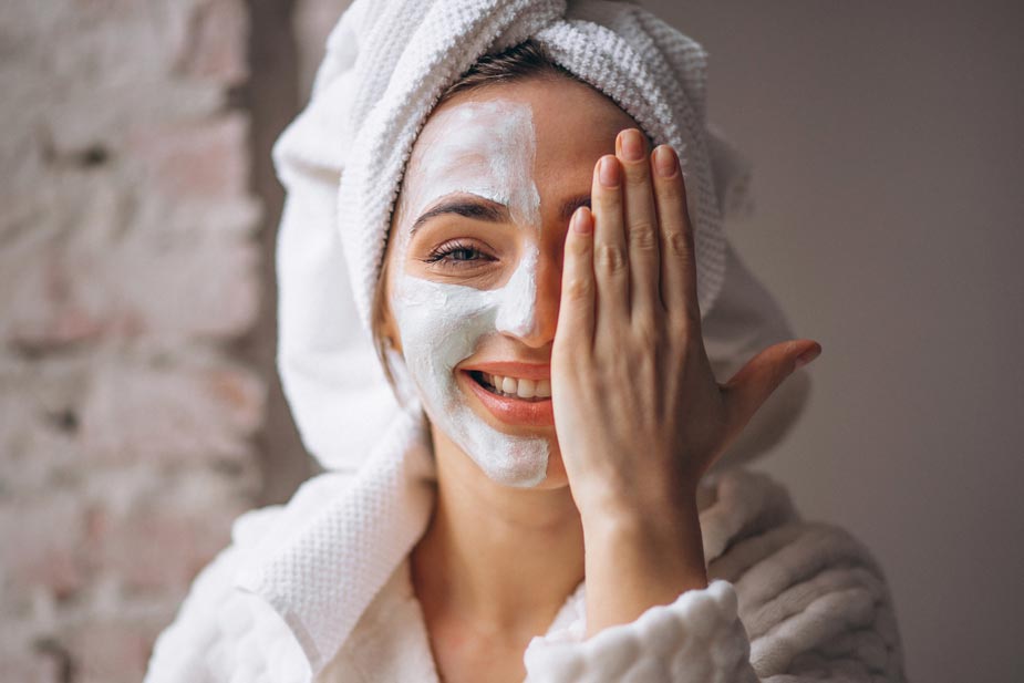 Nasmejana žena sa maskom za čišćenje lica