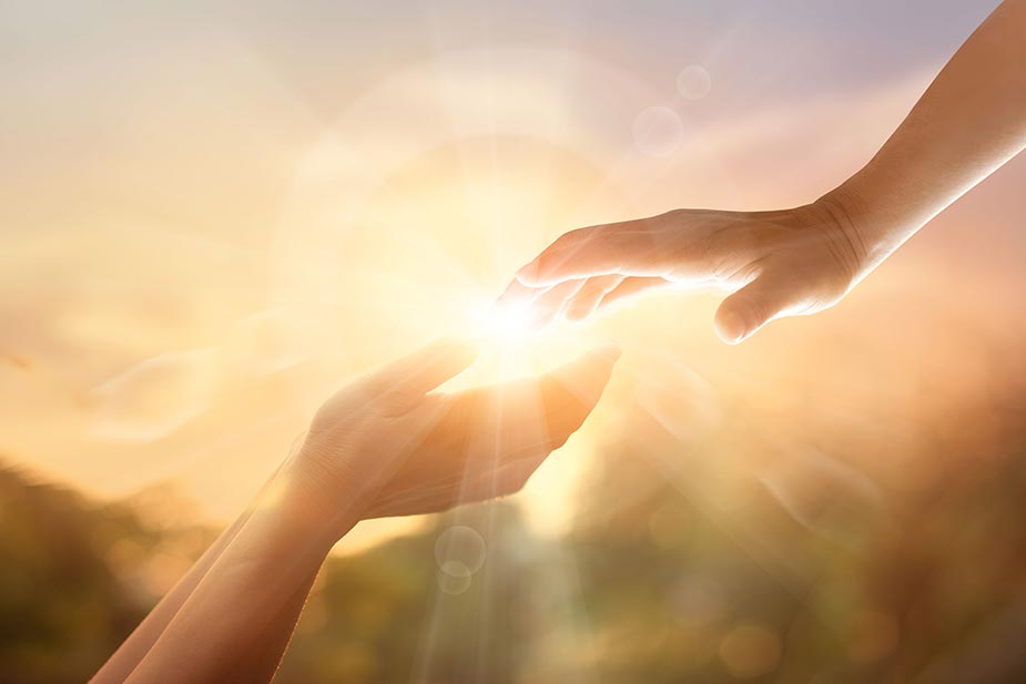 Dve ruke - jedna od dole druga odozgo i kroz njih prolazi svetlosni zrak
