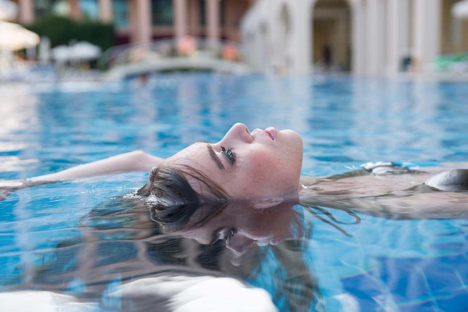 Mlađa žena leđno pliva - plivanje