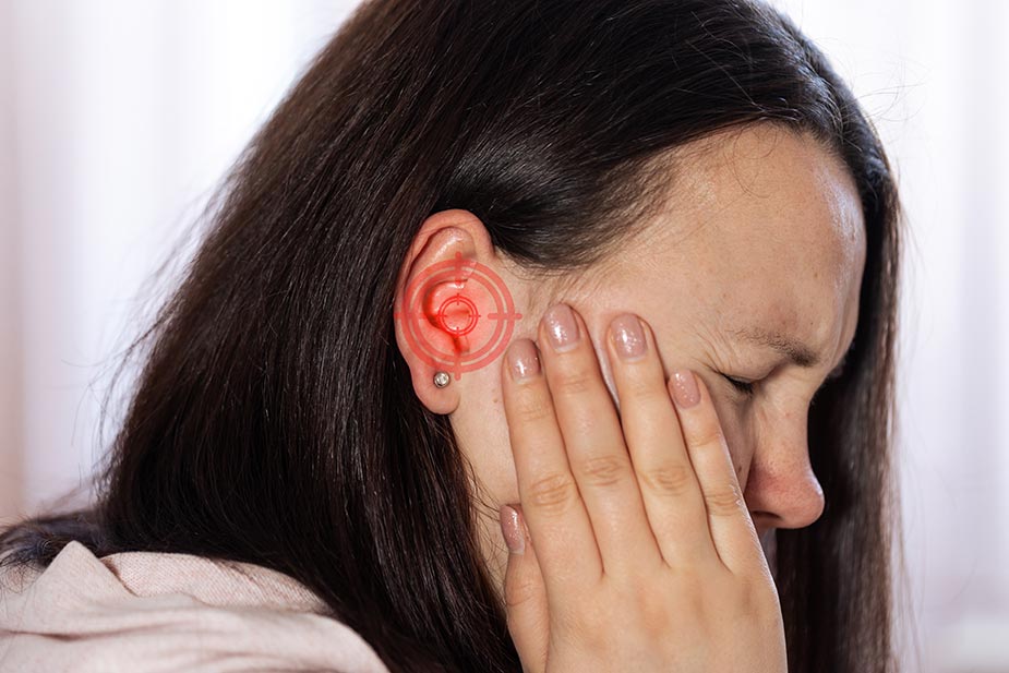 Žena se drži za uvo jer joj smeta upala uha